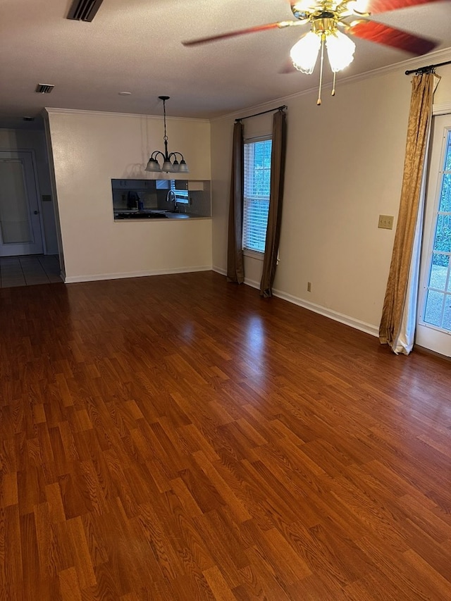 unfurnished living room with a textured ceiling, ceiling fan, ornamental molding, and dark wood-type flooring