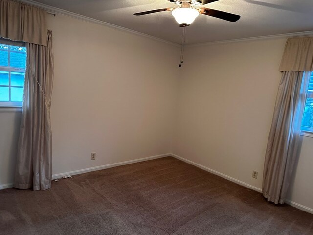 empty room featuring dark colored carpet, ceiling fan, crown molding, and a textured ceiling