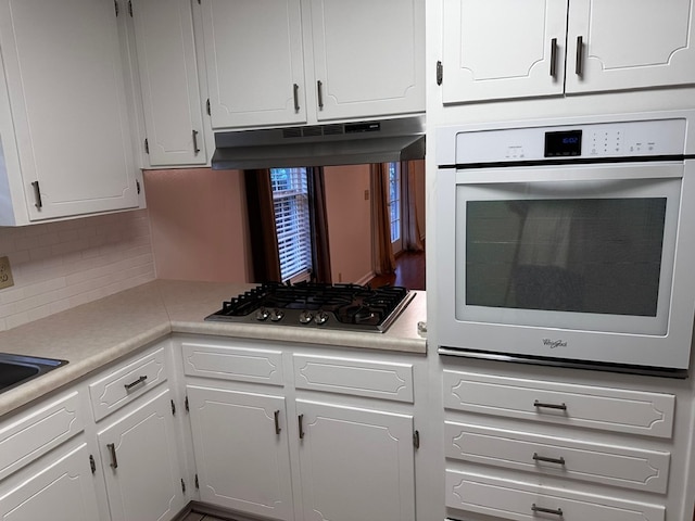 kitchen with white cabinets, appliances with stainless steel finishes, and tasteful backsplash