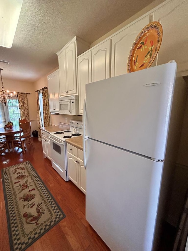 210 Petersburg Ct, Dothan, AL 36301 - kitchen with white cabinets, a notable chandelier, white appliances, light countertops, and dark wood finished floors