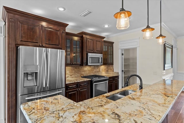 125 Hayley Dr, Enterprise, AL 36330 - kitchen with appliances with stainless steel finishes, ornamental molding, hanging light fixtures, dark brown cabinets, and recessed lighting