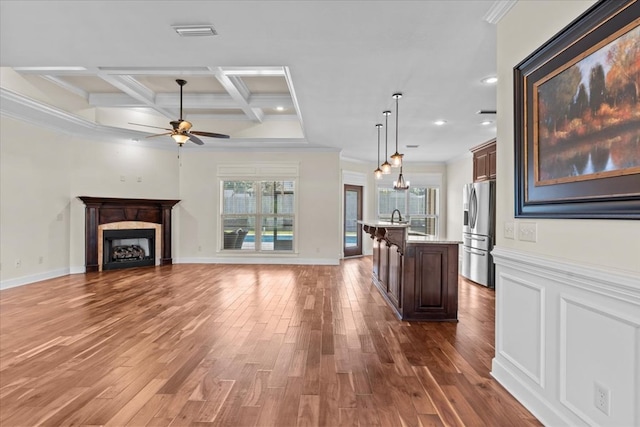 125 Hayley Dr, Enterprise, AL 36330 - unfurnished living room with crown molding, a ceiling fan, wood finished floors, a fireplace, and beam ceiling