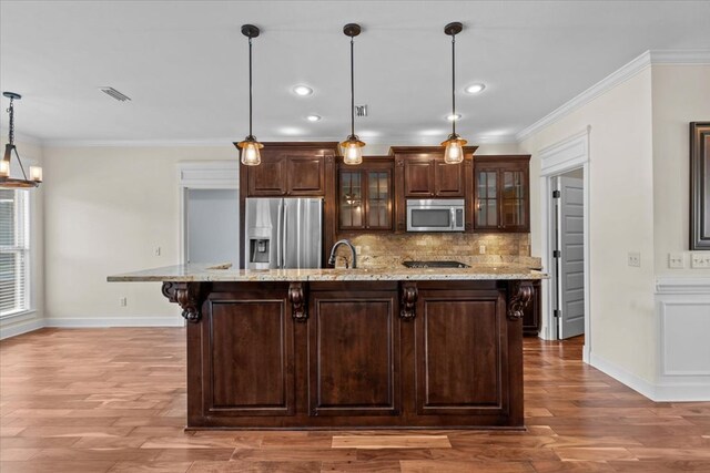 125 Hayley Dr, Enterprise, AL 36330 - kitchen featuring stainless steel appliances, crown molding, a kitchen bar, wood finished floors, and decorative backsplash