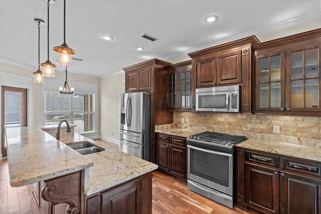 125 Hayley Dr, Enterprise, AL 36330 - kitchen featuring stainless steel appliances, crown molding, tasteful backsplash, an island with sink, and dark brown cabinetry