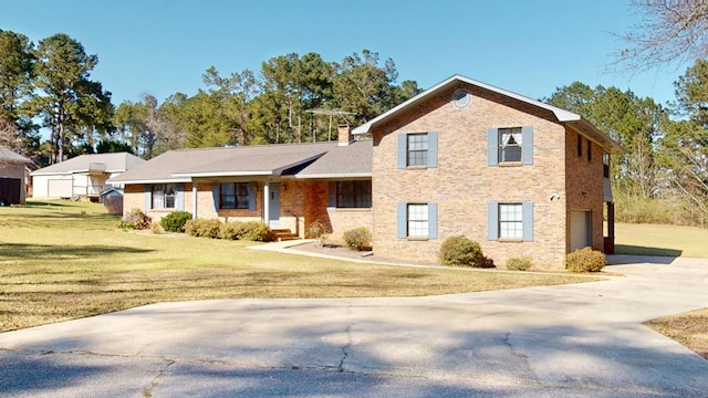 split level home with an attached garage, a chimney, a front lawn, concrete driveway, and brick siding