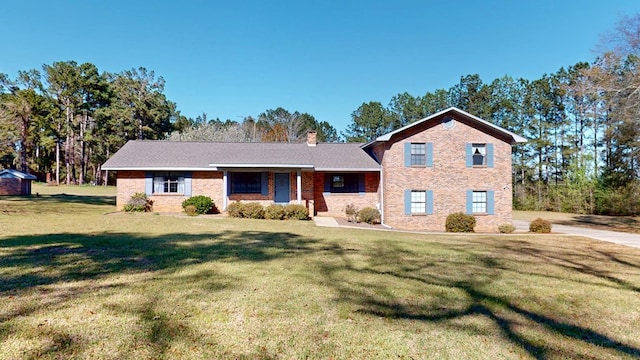 tri-level home with a front yard, brick siding, and a chimney