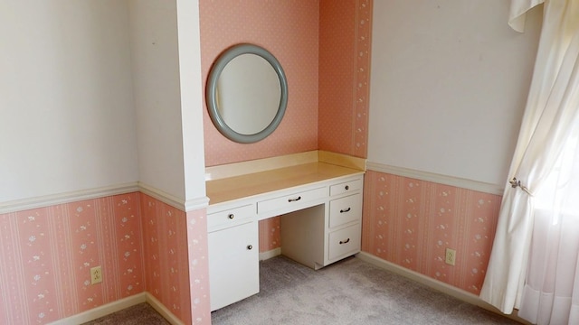 interior space featuring light colored carpet, wallpapered walls, and baseboards