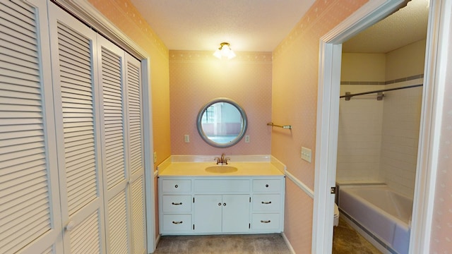 full bathroom featuring wallpapered walls, a closet, and a textured ceiling