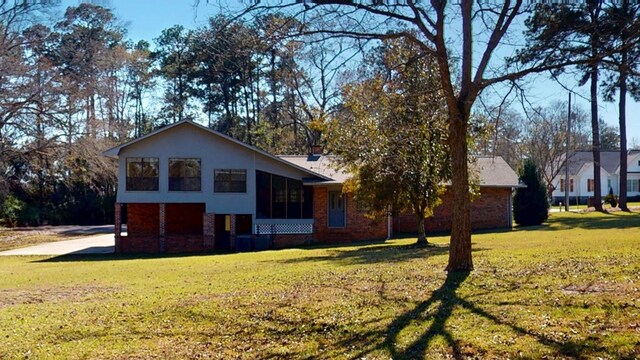 exterior space with brick siding and a front yard