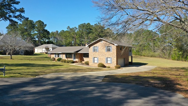 view of front facade featuring a front yard, an attached garage, and driveway