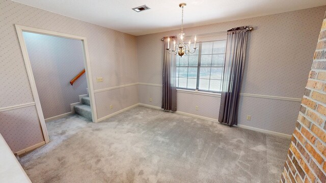 carpeted spare room with visible vents, stairway, an inviting chandelier, wallpapered walls, and baseboards