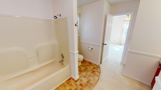 full bathroom with baseboards, toilet, bathtub / shower combination, and a ceiling fan