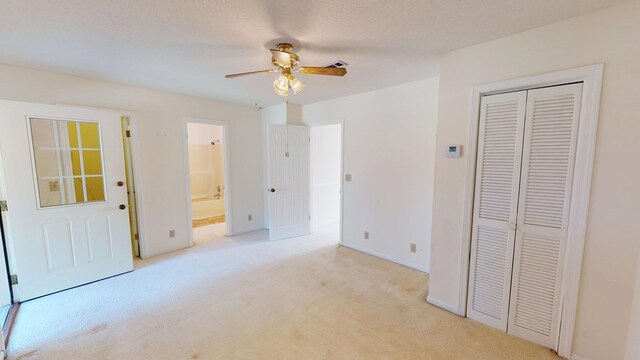 unfurnished bedroom with a ceiling fan, baseboards, carpet floors, ensuite bath, and a closet