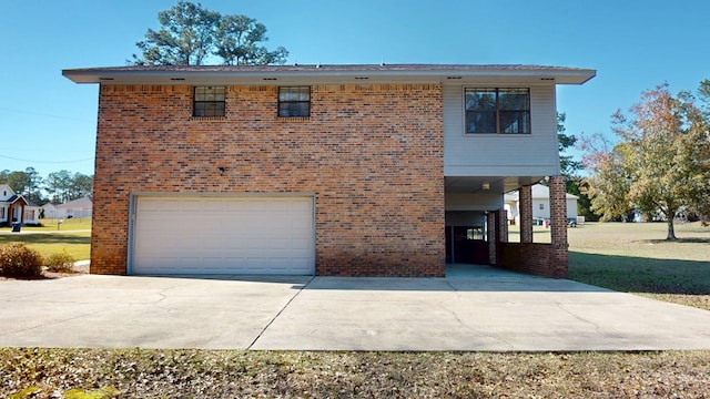 view of front of property with a front yard, concrete driveway, brick siding, and a garage