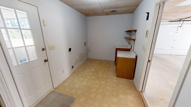 washroom with electric dryer hookup, visible vents, baseboards, light floors, and laundry area