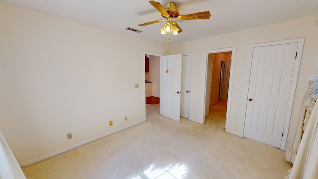 unfurnished bedroom with ceiling fan, light colored carpet, visible vents, and baseboards