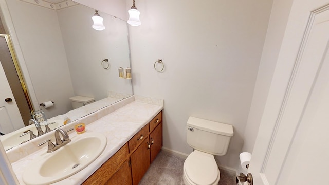 bathroom with toilet, vanity, and baseboards