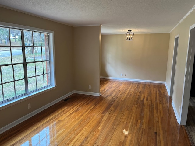 105 Martinson Dr, Abbeville, AL 36310 - spare room featuring plenty of natural light, a textured ceiling, hardwood / wood-style floors, a chandelier, and crown molding