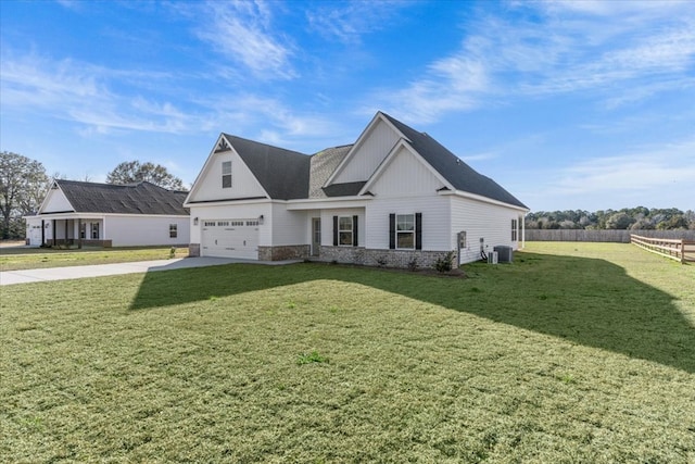 view of front facade with a garage, cooling unit, and a front lawn