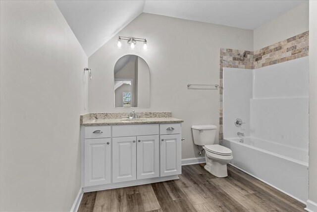 full bathroom with lofted ceiling, wood-type flooring, shower / bathing tub combination, and vanity