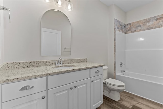 full bathroom featuring hardwood / wood-style flooring, vanity, bathtub / shower combination, and toilet