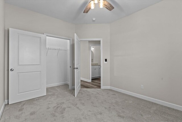 unfurnished bedroom with light colored carpet, ceiling fan, and a closet