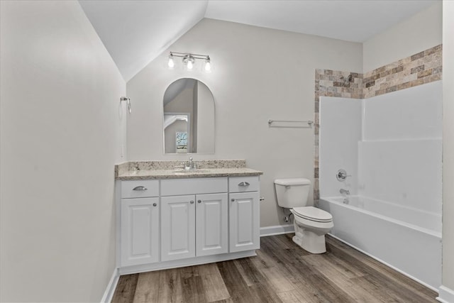 full bathroom with vanity, hardwood / wood-style flooring, vaulted ceiling, and bathing tub / shower combination