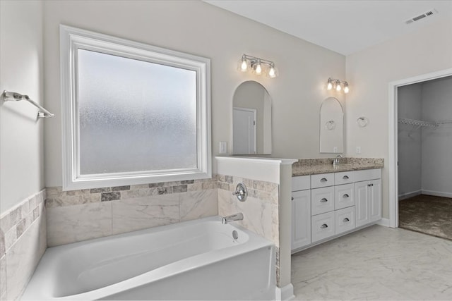 bathroom featuring vanity and a tub