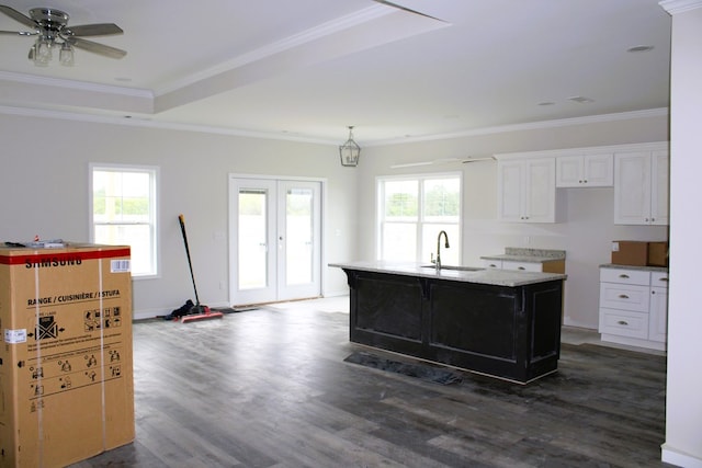 kitchen with a center island with sink, white cabinetry, sink, and a wealth of natural light