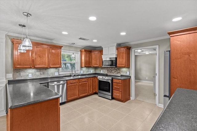 1401 Deese Rd, Ozark, AL 36360 - kitchen with stainless steel appliances, dark countertops, crown molding, brown cabinetry, and decorative backsplash