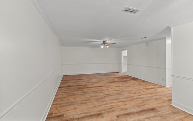 unfurnished room featuring a textured ceiling, light wood-type flooring, ceiling fan, and ornamental molding