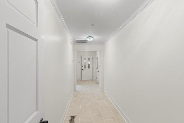 hallway with ornamental molding and light tile patterned flooring