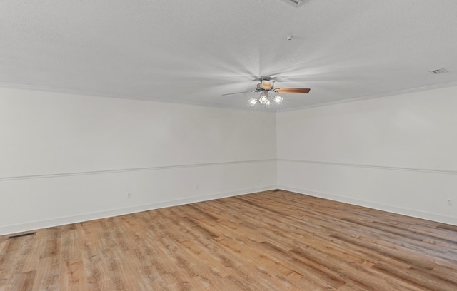 spare room featuring a textured ceiling, light hardwood / wood-style floors, and ornamental molding