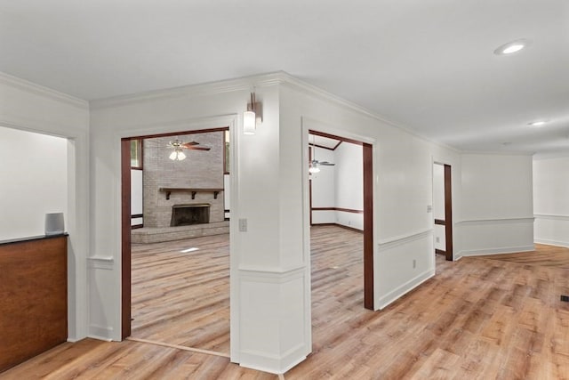 hallway featuring ornamental molding and light hardwood / wood-style flooring