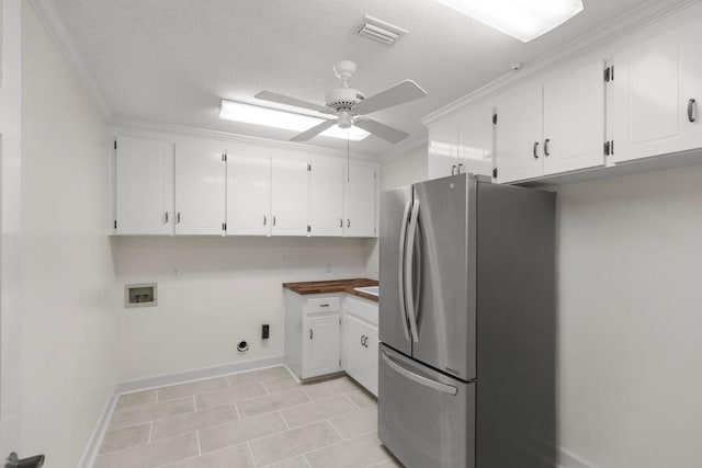 kitchen featuring ceiling fan, light tile patterned floors, stainless steel fridge, a textured ceiling, and white cabinets