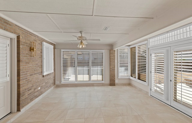 unfurnished sunroom with ceiling fan