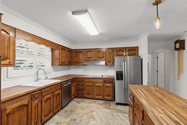 kitchen featuring stainless steel appliances, hanging light fixtures, crown molding, and sink