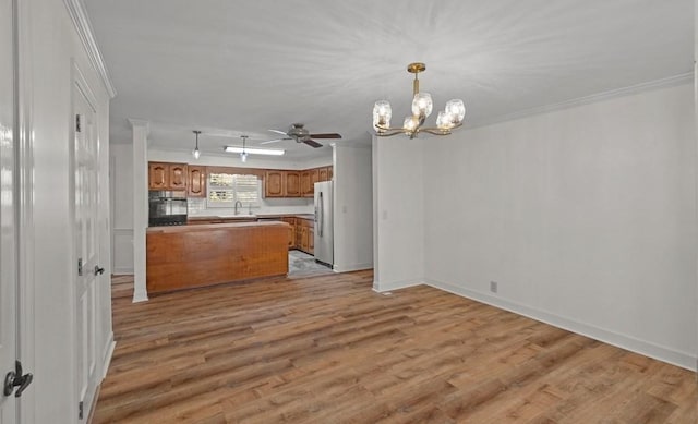 kitchen featuring a chandelier, light hardwood / wood-style flooring, stainless steel refrigerator, and crown molding