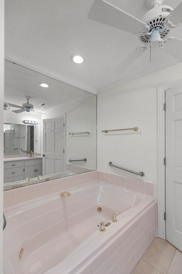 bathroom with tile patterned floors, tiled bath, crown molding, and vanity