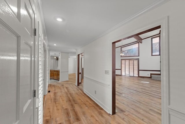 hall featuring light wood-type flooring and ornamental molding