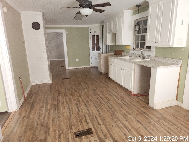 kitchen featuring white cabinets, decorative light fixtures, light hardwood / wood-style flooring, and sink