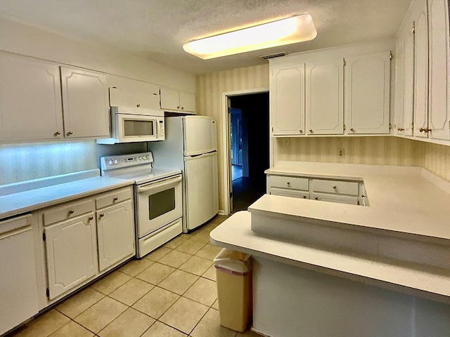 kitchen featuring light tile patterned floors, white appliances, and white cabinetry