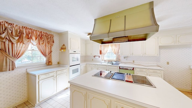 709 Rosemont Dr, Dothan, AL 36303 - kitchen featuring extractor fan, double oven, light countertops, and wallpapered walls