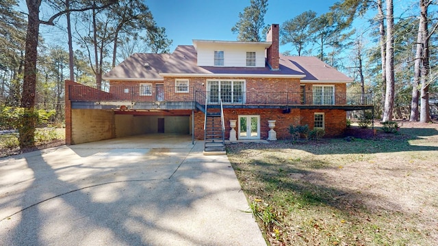 709 Rosemont Dr, Dothan, AL 36303 - rear view of property with stairway, a chimney, concrete driveway, a garage, and brick siding