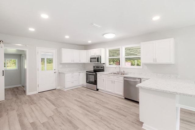 kitchen featuring a wealth of natural light, sink, white cabinets, and appliances with stainless steel finishes