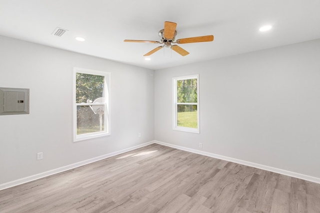 spare room with electric panel, light hardwood / wood-style floors, and ceiling fan