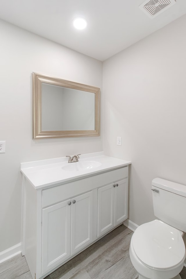 bathroom featuring hardwood / wood-style flooring, vanity, and toilet