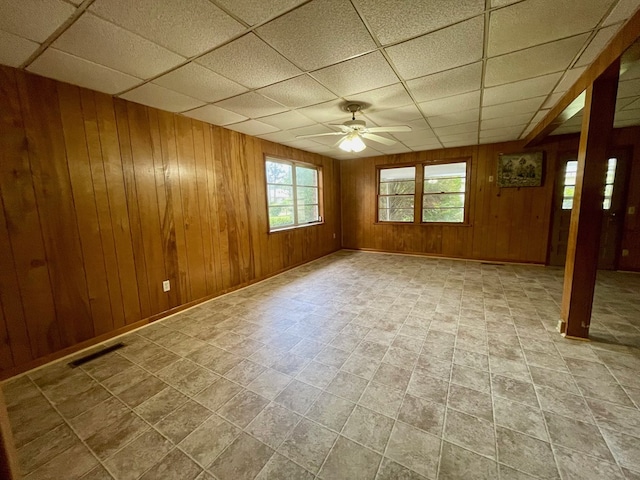 1105 Deborah St, Dothan, AL 36301 - empty room featuring a drop ceiling, a ceiling fan, and wood walls