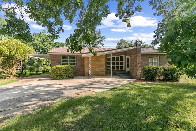 1105 Deborah St, Dothan, AL 36301 - view of front facade with a front yard, brick siding, a metal roof, a chimney, and driveway