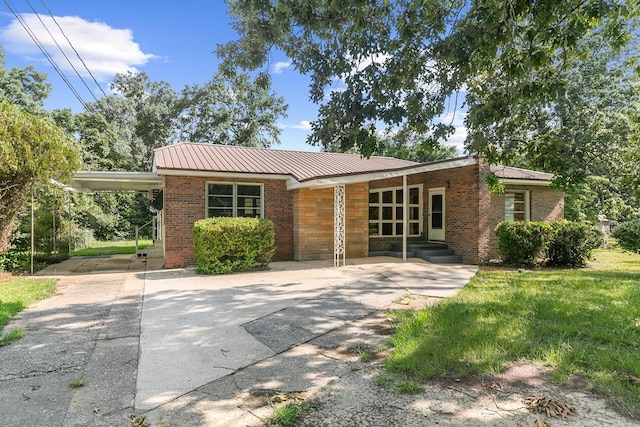 1105 Deborah St, Dothan, AL 36301 - view of front facade with driveway, a metal roof, a carport, and brick siding